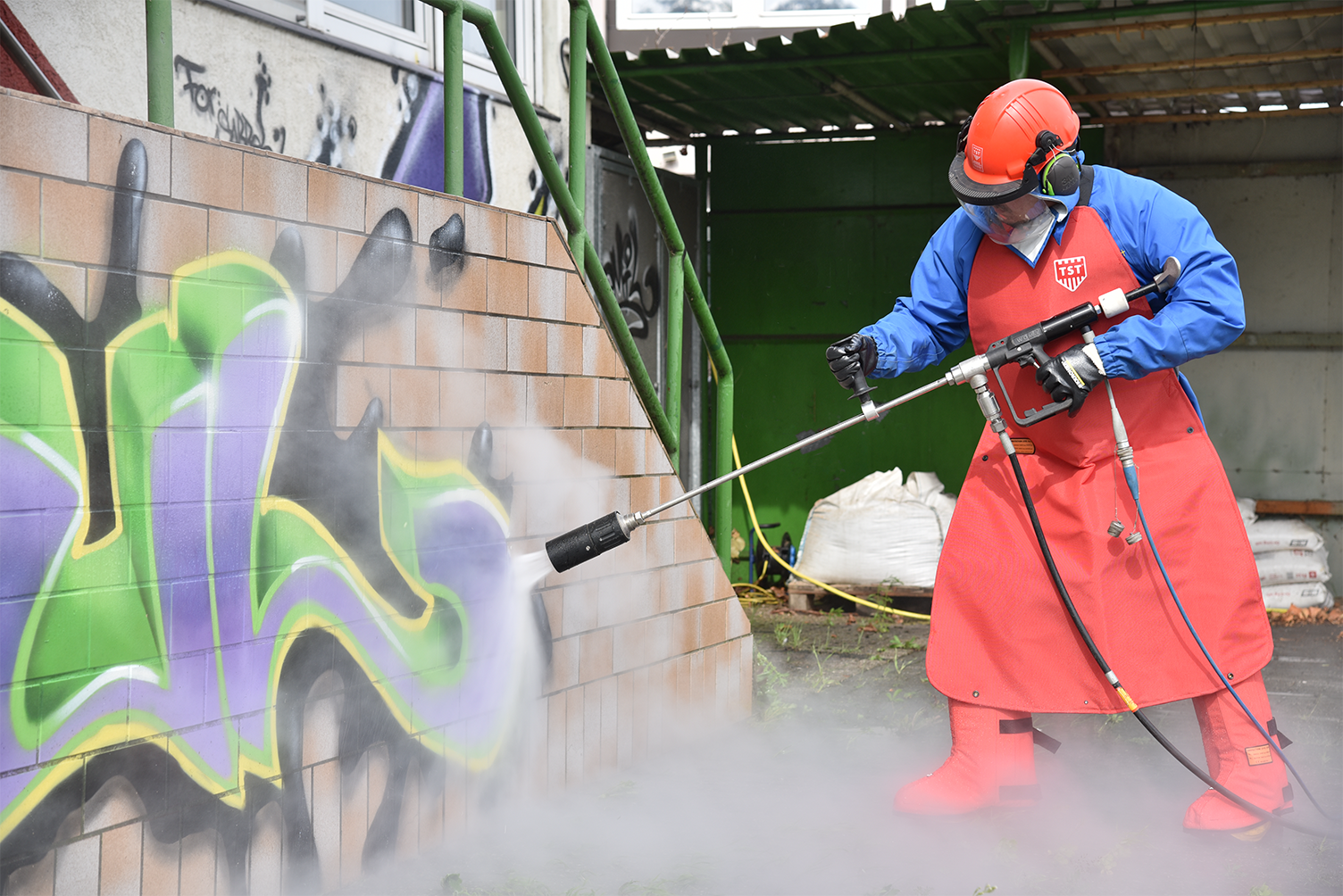 WOMA EcoTherm hot water unit removing graffiti from a wall